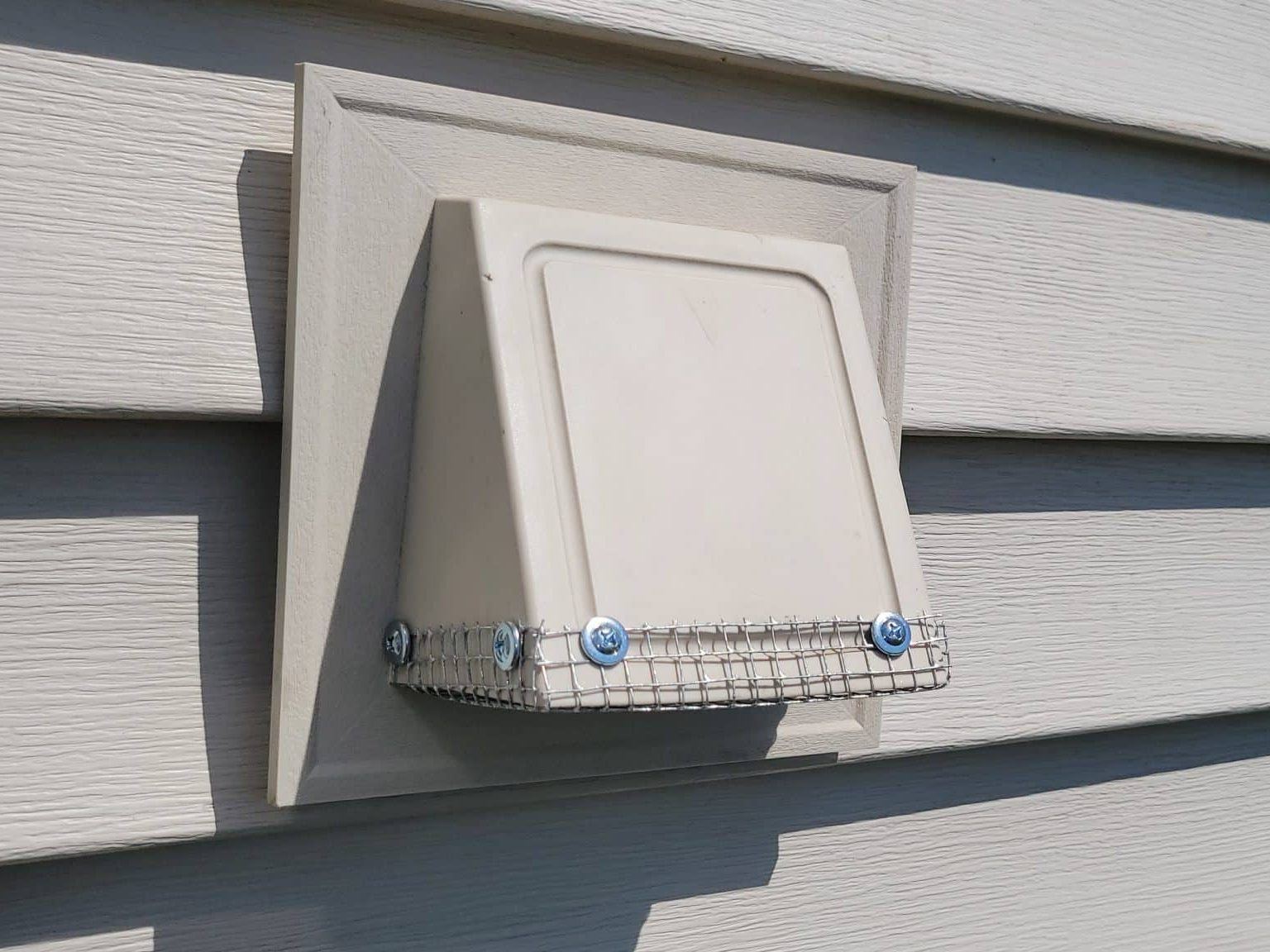 Bird guard mesh installed over an exterior dryer vent to stop nesting