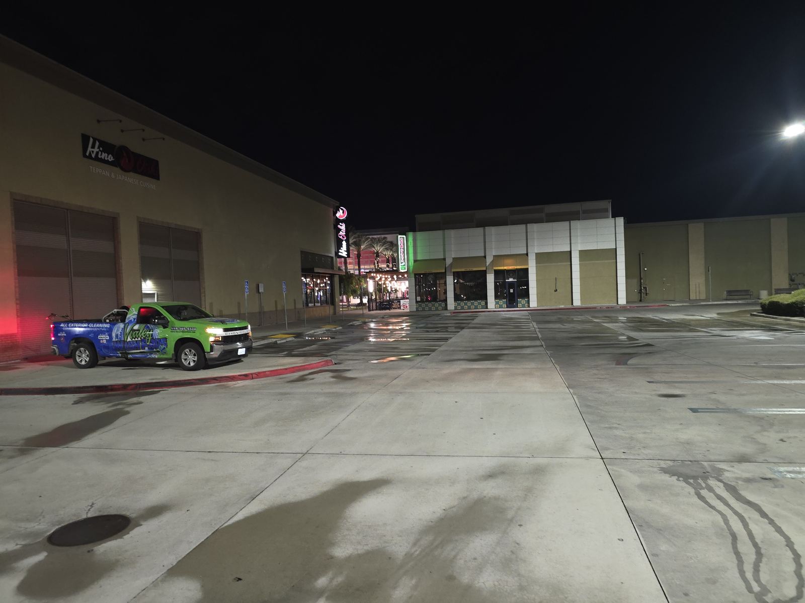 Freshly power washed sidewalk at a Central Valley retail plaza with the Valley Wash Pros truck staged at the storefront