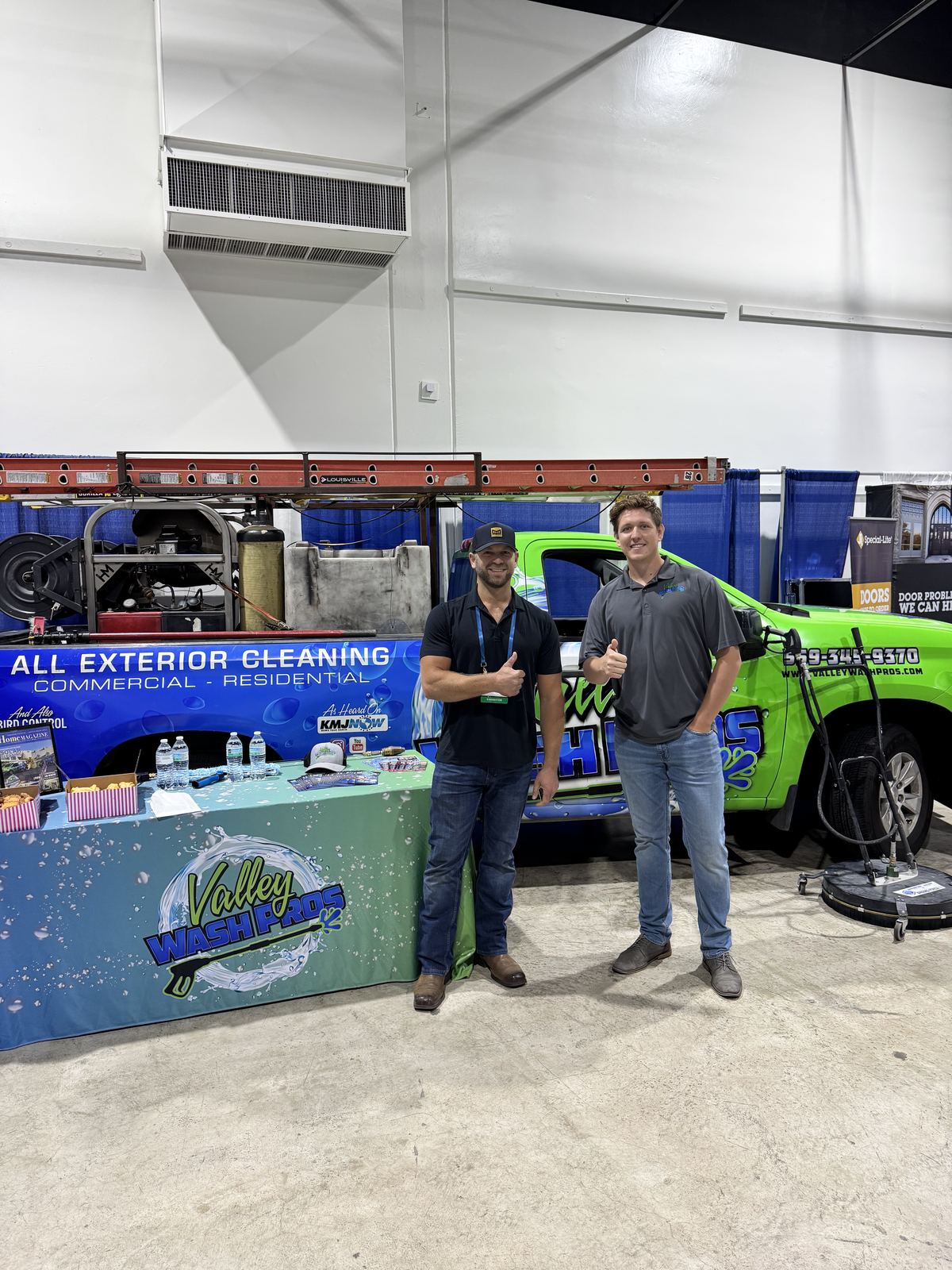 Valley Wash Pros team at their home show booth with the company trucks on display