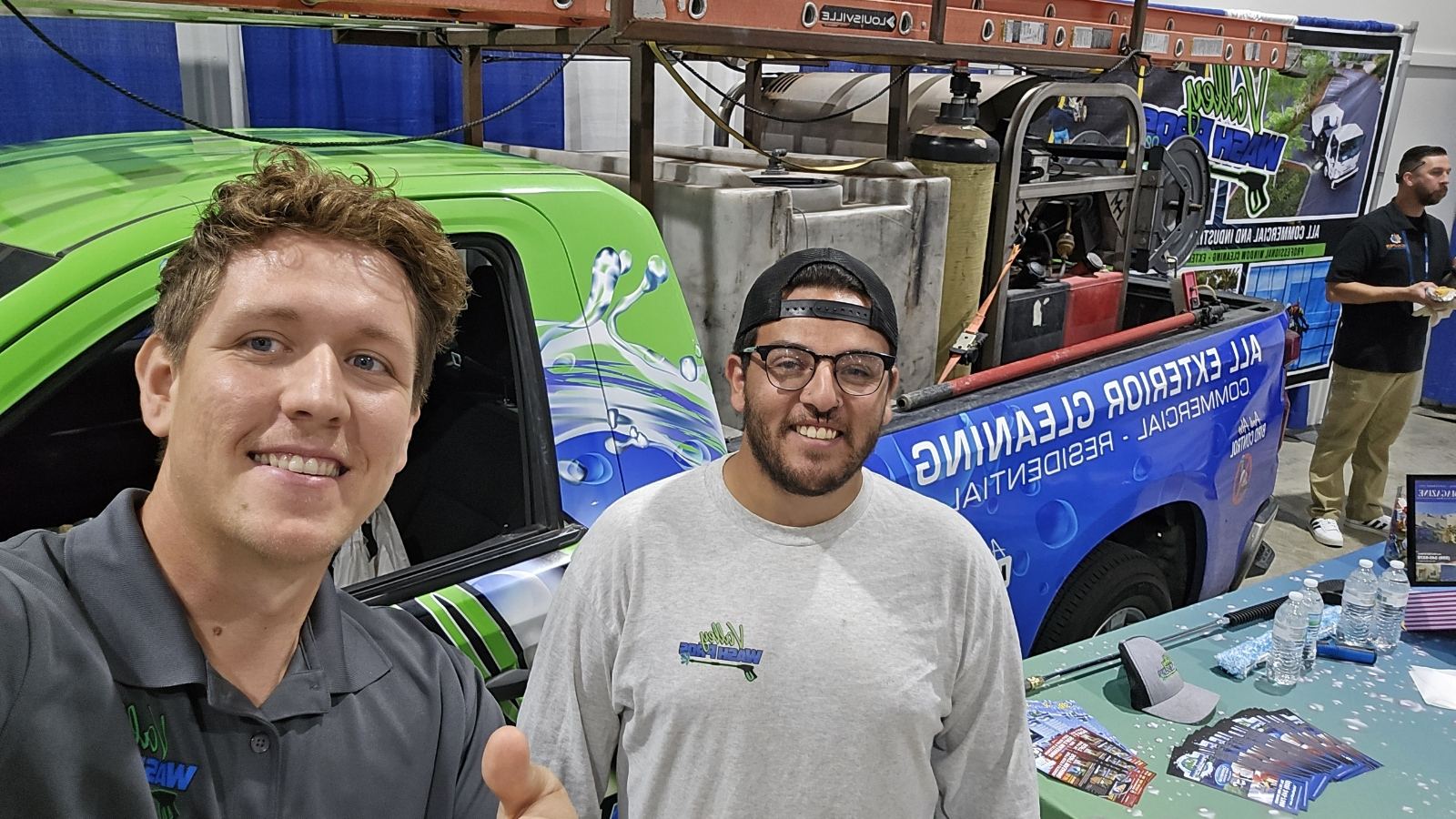 Two Valley Wash Pros crew members standing in front of the wrapped company truck
