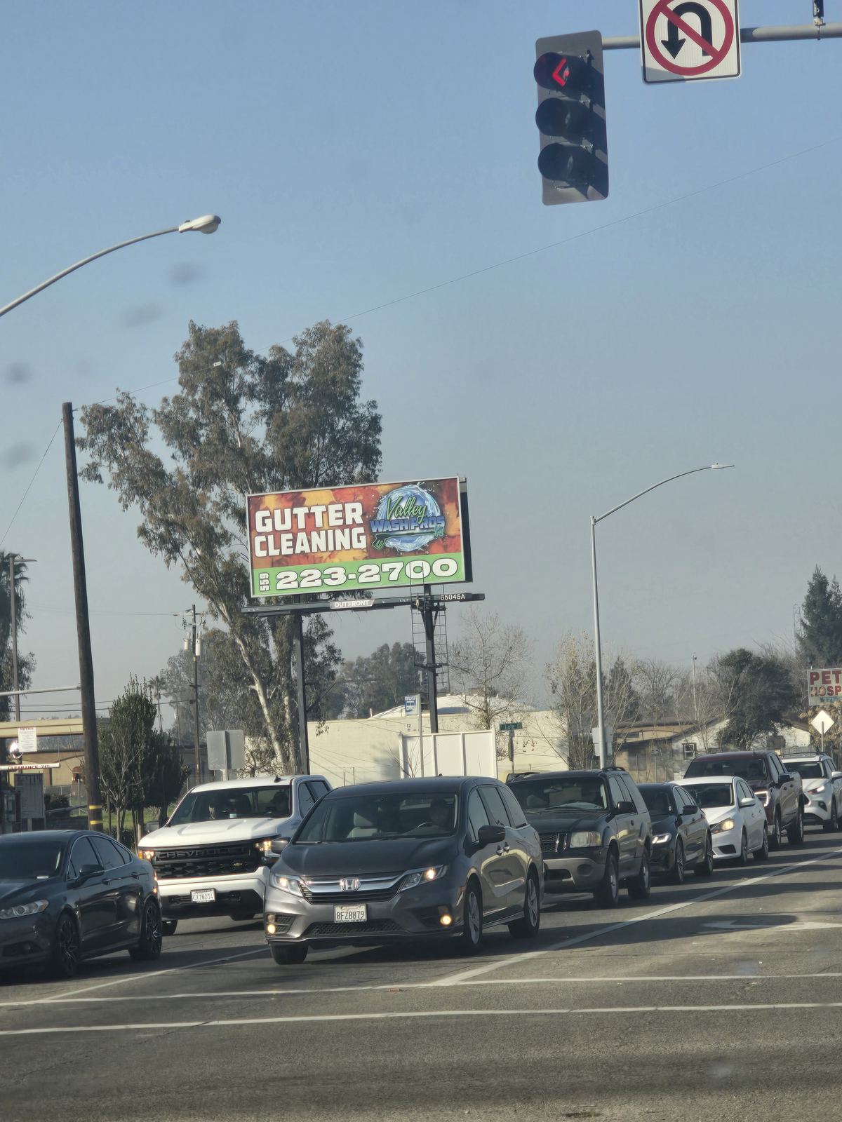 Valley Wash Pros gutter cleaning billboard above a busy Fresno street