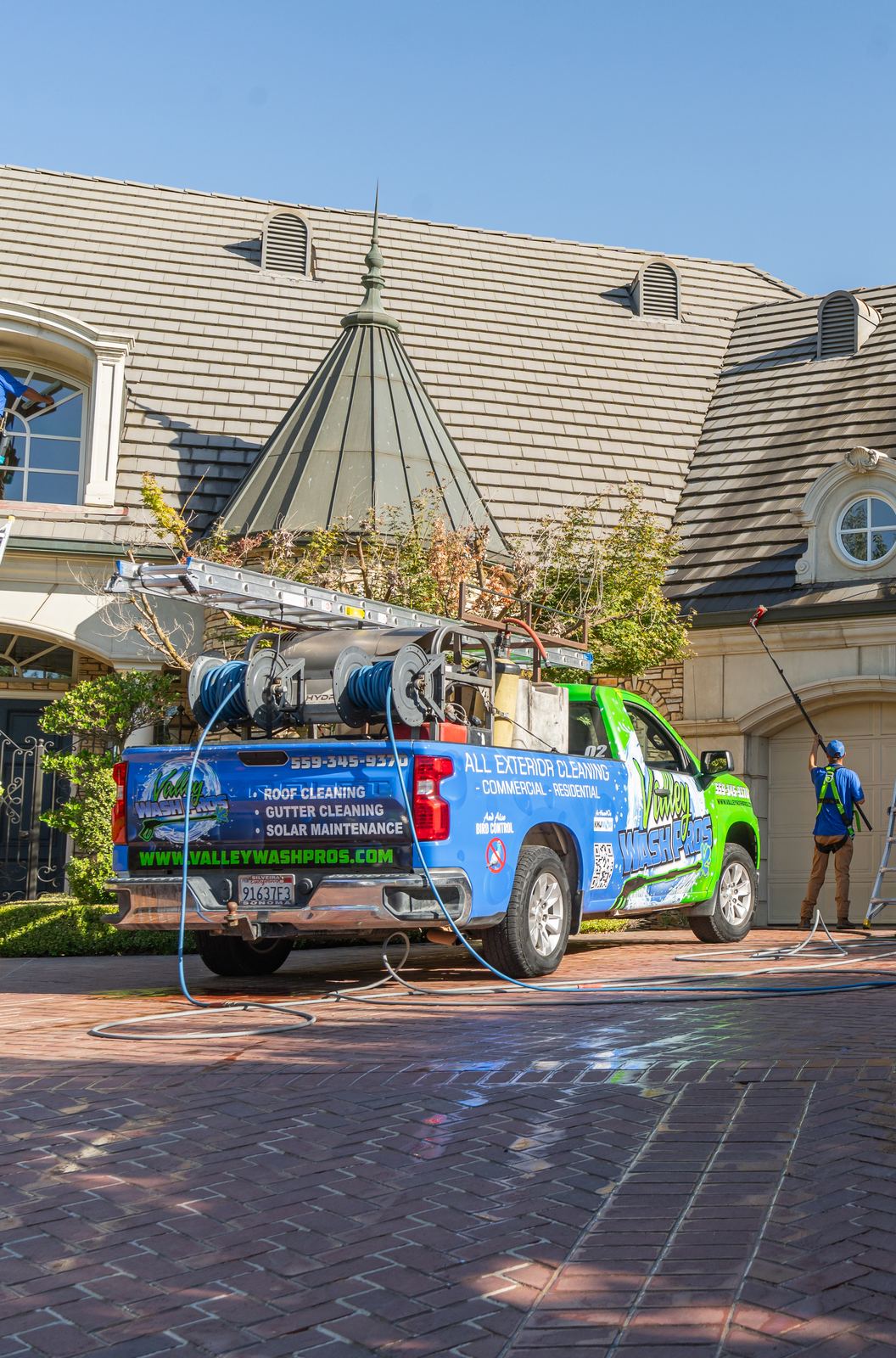 Valley Wash Pros wrapped truck listing roof cleaning, gutter cleaning and solar maintenance on a Fresno job