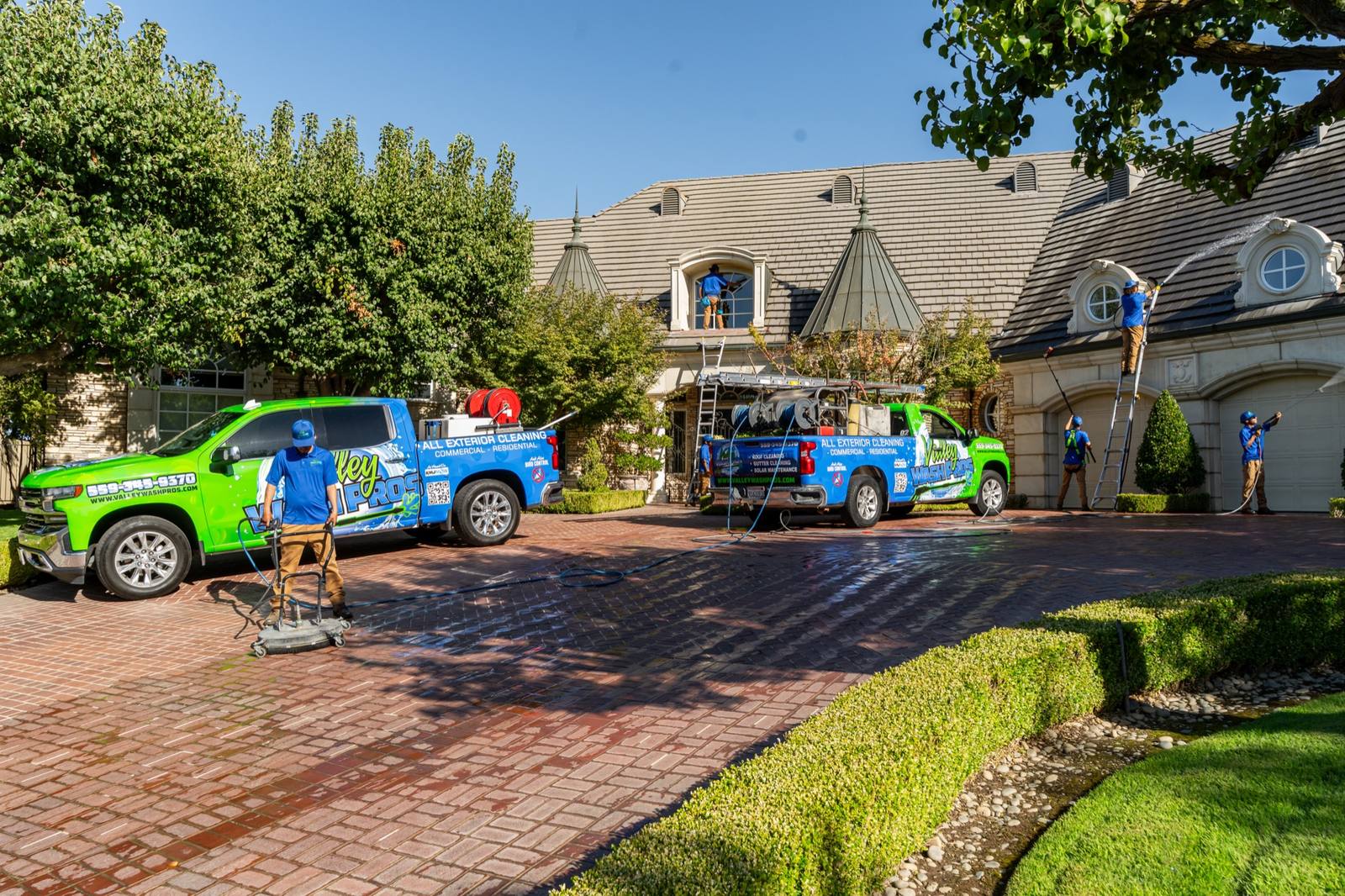Two Valley Wash Pros crew members standing with the branded service van