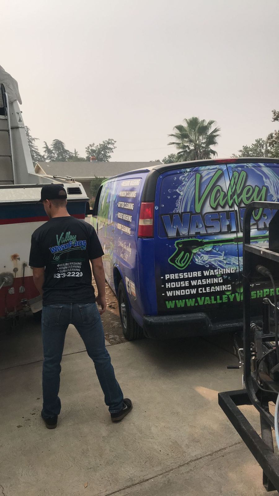 Technician walking to the Valley Wash Pros service van on a job