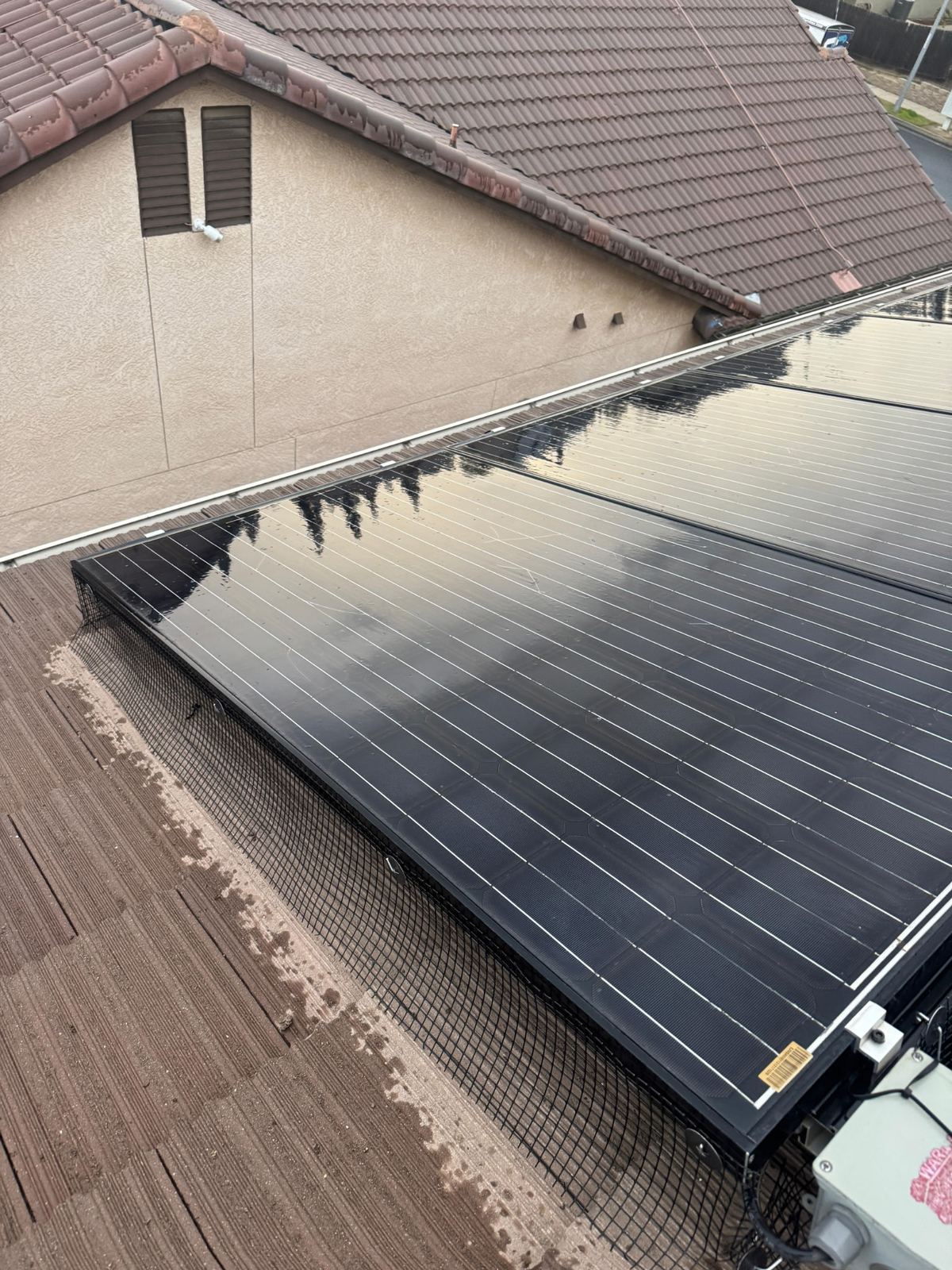 Freshly cleaned solar panel array on a Fresno concrete tile roof, panels dark and streak free
